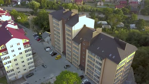 Luftaufnahme eines mehrstöckigen Mehrfamilienhauses in einer grünen Wohngegend.