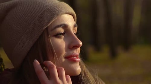 Smiling Woman Wearing Beanie in Golden Sunlight