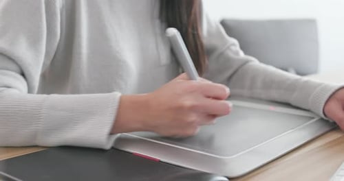 Designer arbeitet zu Hause an Zeichenblock und Computer