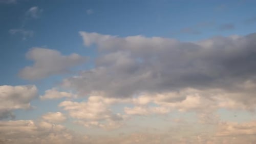 Time lapse footage of fast moving white clouds on blue clear sky.