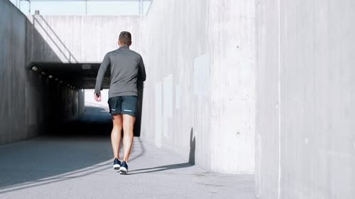 Young Man Running Along City Street