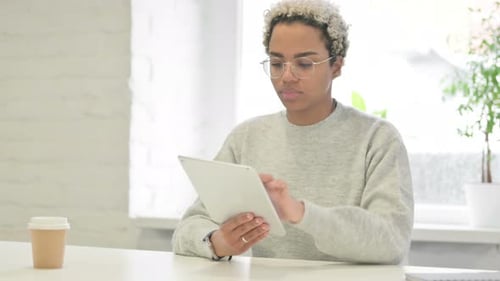 African Woman Using Tablet While Sitting in Office