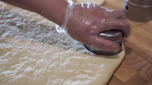 Der Bäcker schneidet das Donut-Gebäck in runde Formen