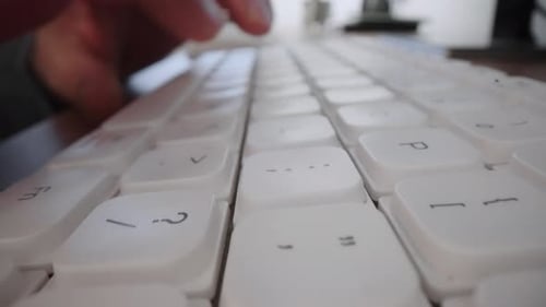 Fingers Typing on a White Computer Keyboard