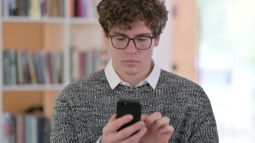 Young Adult Using Smartphone Indoors Close Up