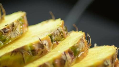 Delicious Pineapple Slices Displayed on Black Surface