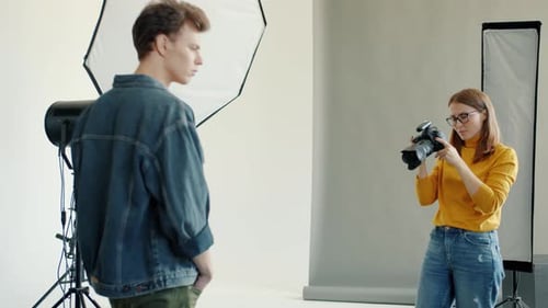 Model Posing as Photographer Takes Pictures in Studio