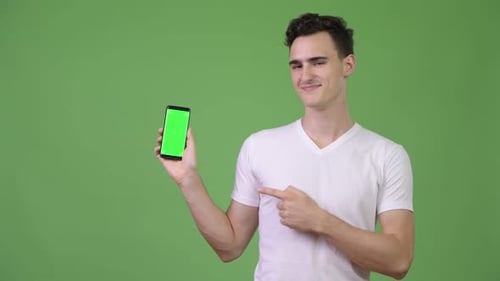 Young Man Holding Phone With Green Screen, Thumbs Up