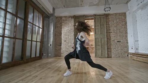 Energetic Woman Dancing Freely in Bright Studio