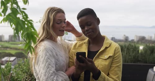 Two Women Enjoying Smartphone in Urban Environment