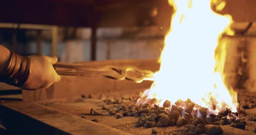 Blacksmith Heats Horseshoe in Fiery Forge