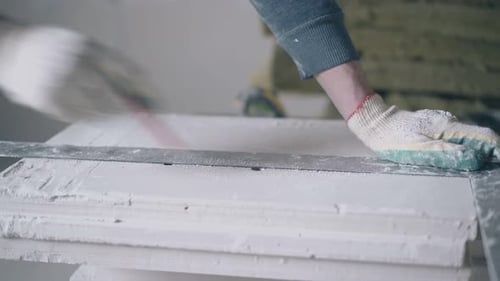 Worker Marking Drywall Board with Pencil and Ruler