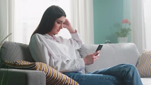 Young Woman Relaxing at Home with Mobile Phone