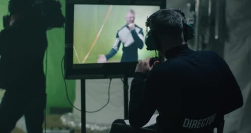 El director da instrucciones y observa la escena en el monitor