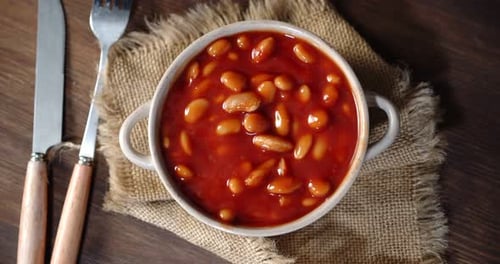 Bowl of Beans in Sauce on Wood Table