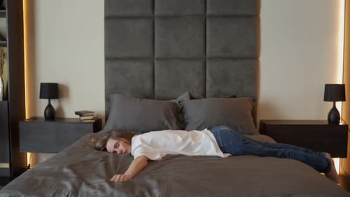 Tired Woman Collapses on the Bed