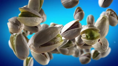 Slow Motion Falling Pistachios on Blue Background