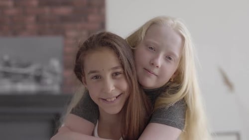 Smiling Girls Embracing Indoors