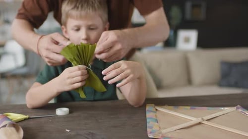 Little Boy Making Paper Bow