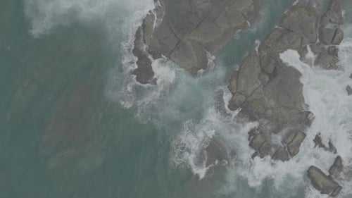 Waves Crash Against Rocks in the Ocean