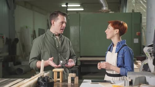 Man and Woman Joiners Using Digital Tablet While Working in Workshop