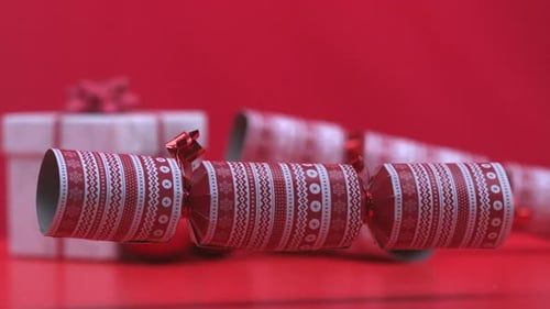 Christmas cracker dropping and bouncing beside present and bauble