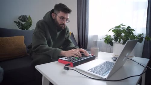 Man Creating Music at Home on Keyboard