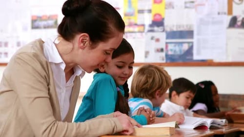 Teacher Helping Students Read in Classroom