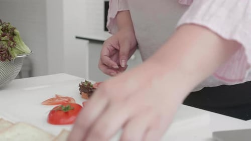 Woman Making and Eating a Sandwich at Home
