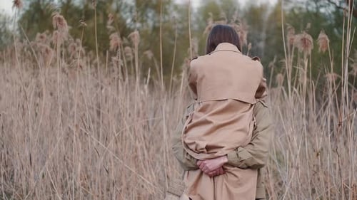 Young Couple in Beige Coats Spending Time Outdoors