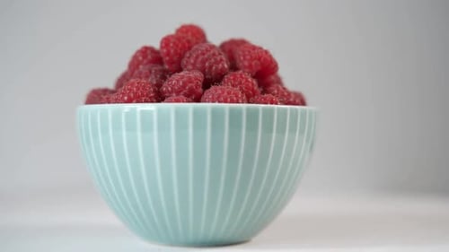 Süße Himbeeren in einem süßen blauen Teller
