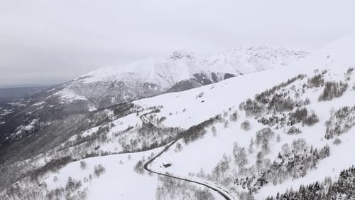 Aerial View of Snow Capped Mountain Range Landscape in Winter During Sunset