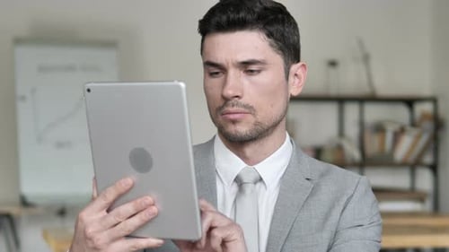Man Uses Tablet in Bright Office Setting
