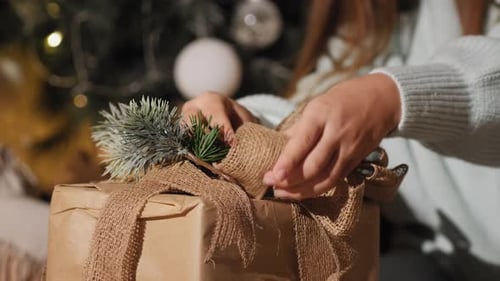 Female Hands Preparing Gifts for Xmas, Close-up
