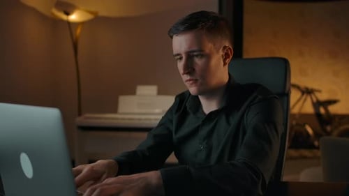 Young Adult Working on Laptop at Home Answering Phone