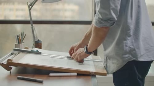 Man Drafting at Table in Office Daytime