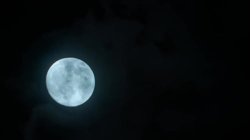 Full Moon Ascends in the Cloudy Night Sky