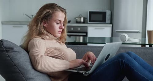 Woman Works on Laptop Computer at Home