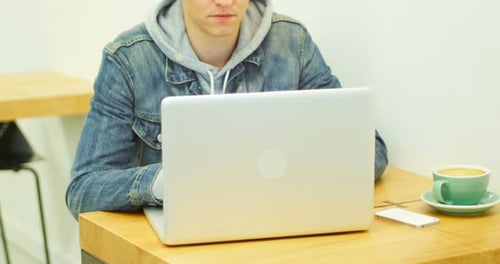 Young Adult Working on Laptop at Table