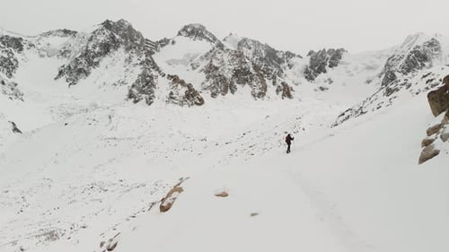 Person Hiking in Snowy Mountain Winter Landscape