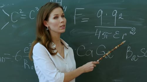 Female Teacher Explaining Math in Front of Chalkboard