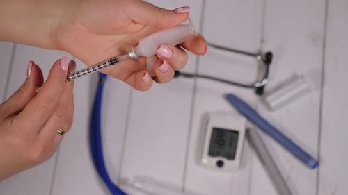Closeup of a Woman Taking Insulin with a Syringe