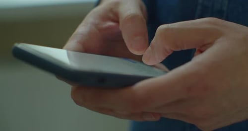 Adult Hands Typing on Smartphone Device Close Up