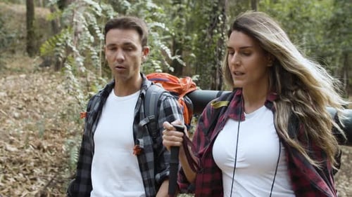 Couple Hiking Through a Dense Green Forest