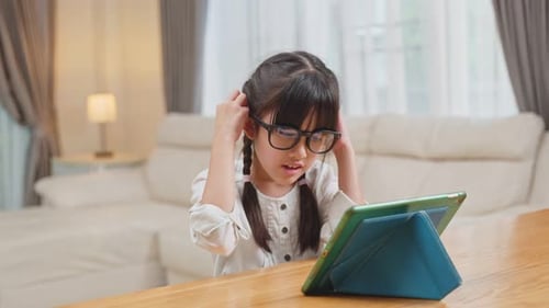 Child Uses Tablet, Puts on Glasses Indoors
