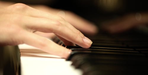 Woman's hands playing music on a piano