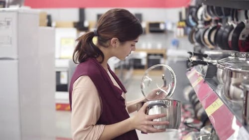 Young Female Costumer Looking for Kitchenware Holding a Steel Cook Pot