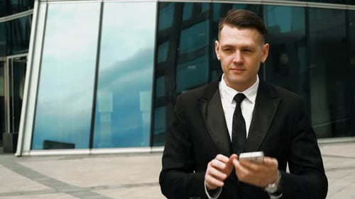 Young Adult Businessman Answering a Phone Call