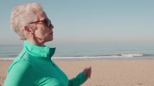 Senior Woman Exercising At The Beach