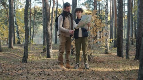 Man and Teen Hike and Navigate With a Map